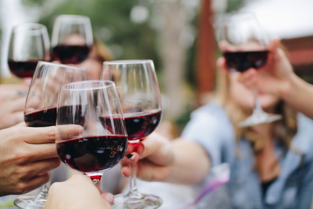 People clinking their glasses of red wine